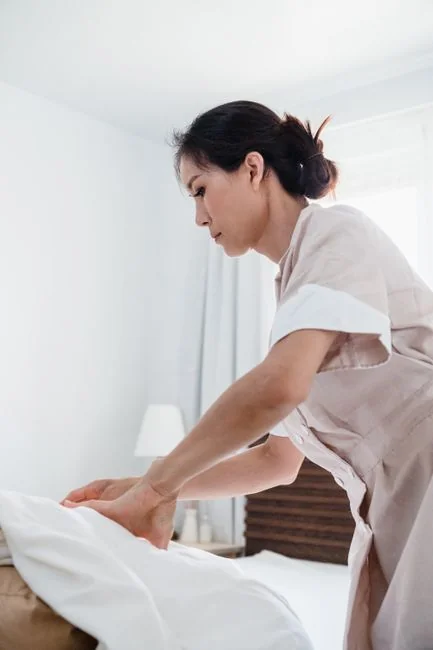 Un couple heureux installe un canapé dans leur nouvelle maison, entouré de cartons de déménagement.