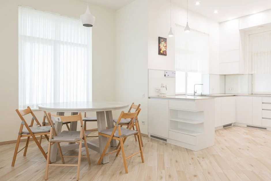 Un couple range son salon, réorganisant meubles et tapis en travaillant ensemble.